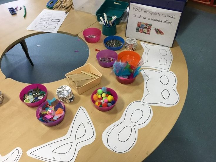 a wooden table topped with bowls filled with candy and paper cut outs on top of it