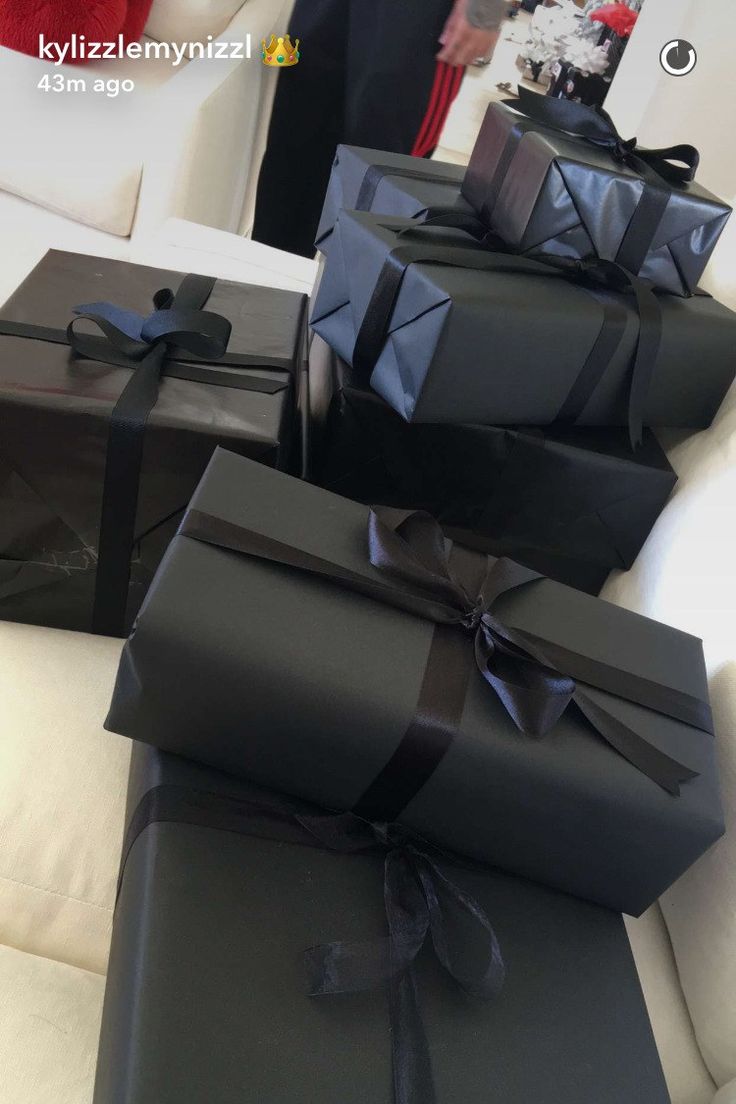 black wrapped presents sitting on top of a white couch