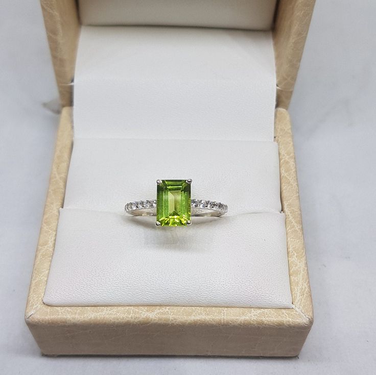 14k solid white gold natural AAA quality emerald cut rectangular shaped peridot gemstone and natural round brilliant cut shaped diamonds gemstones ring. 1. The weight of natural peridot gemstone used in the ring =1.40 cts. 2. The weight of natural diamonds gemstones used in the ring =0.20 cts. 3. The weight of 14k solid white gold used in the ring =2.350 grms. 4. The design of the ring is very very nice and beautiful. 5. The peridot is the birthstone for the people born in the month of August. 6 Green Peridot Birthstone Ring For Formal Occasions, Green Peridot Birthstone Ring For Formal Events, White Gold Peridot Rings With Prong Setting, Green Topaz Ring In Sterling Silver, Green Topaz Sterling Silver Ring In Fine Jewelry Style, Green Topaz Sterling Silver Ring, Green Topaz Ring With Emerald Cut And Accent Stones, Green Emerald Cut Topaz Ring With Accent Stones, Emerald Cut Green Topaz Ring With Accent Stones