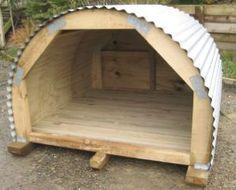 a wooden structure with metal roof sitting on the ground