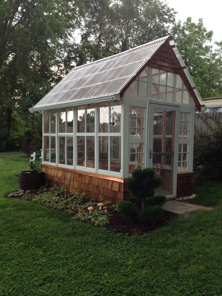 a small greenhouse in the middle of a yard