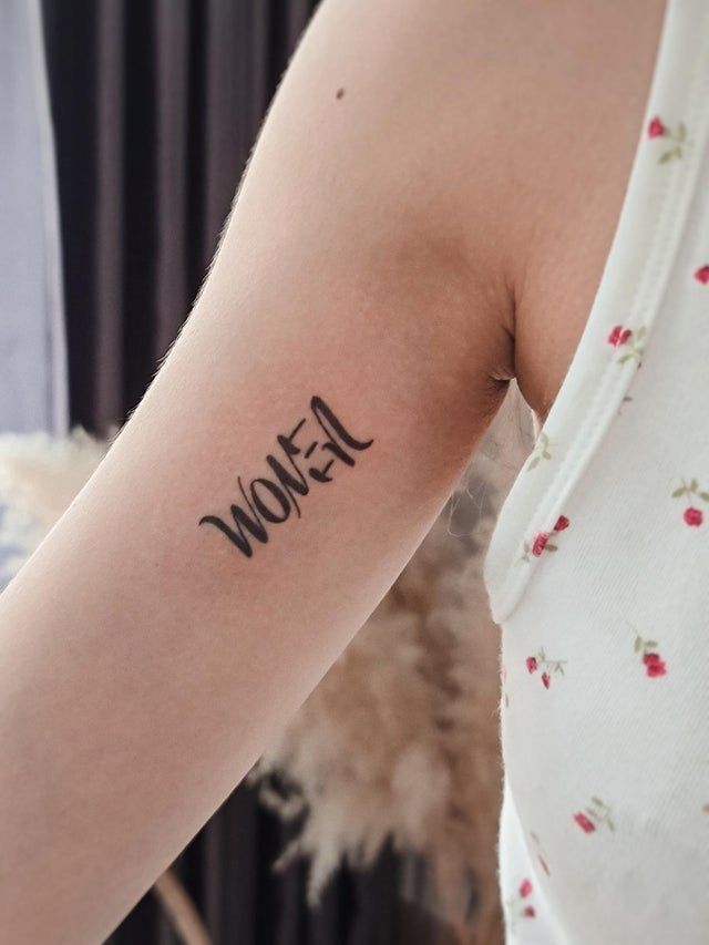 a woman's arm with the word women written in cursive writing on it