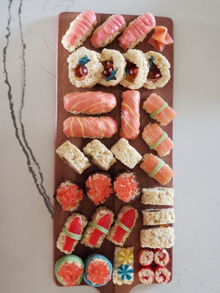 an assortment of sushi on a wooden board