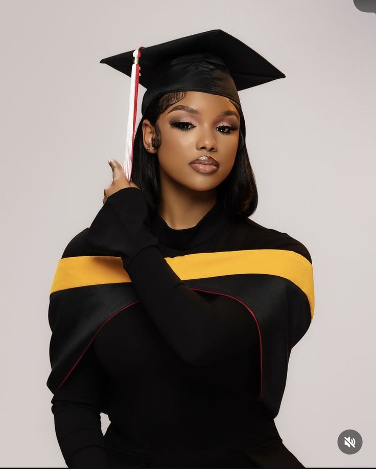 a woman wearing a graduation cap and gown with her hand on her shoulder, posing for the camera