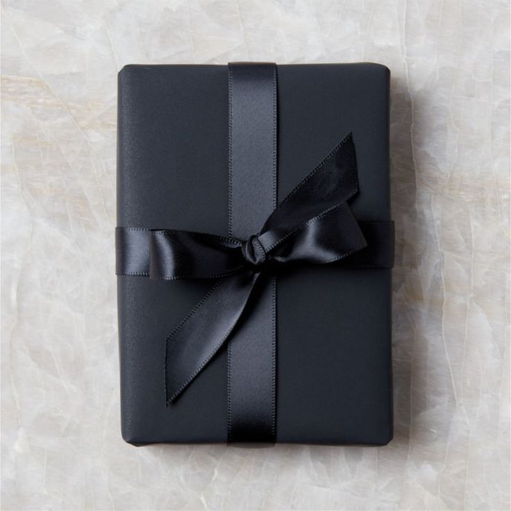 a black wrapped gift with a bow on it