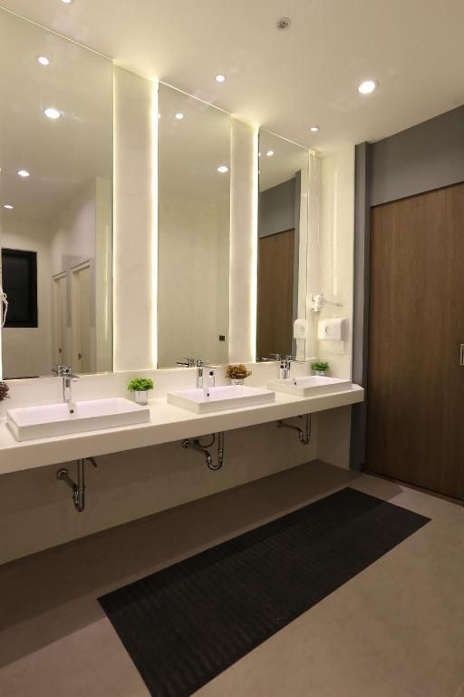 a bathroom with double sinks and mirrors in it's center wall, along with lights on either side of the mirror