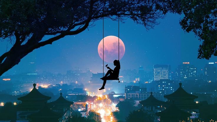 a person sitting on a swing in the air over a city at night with full moon