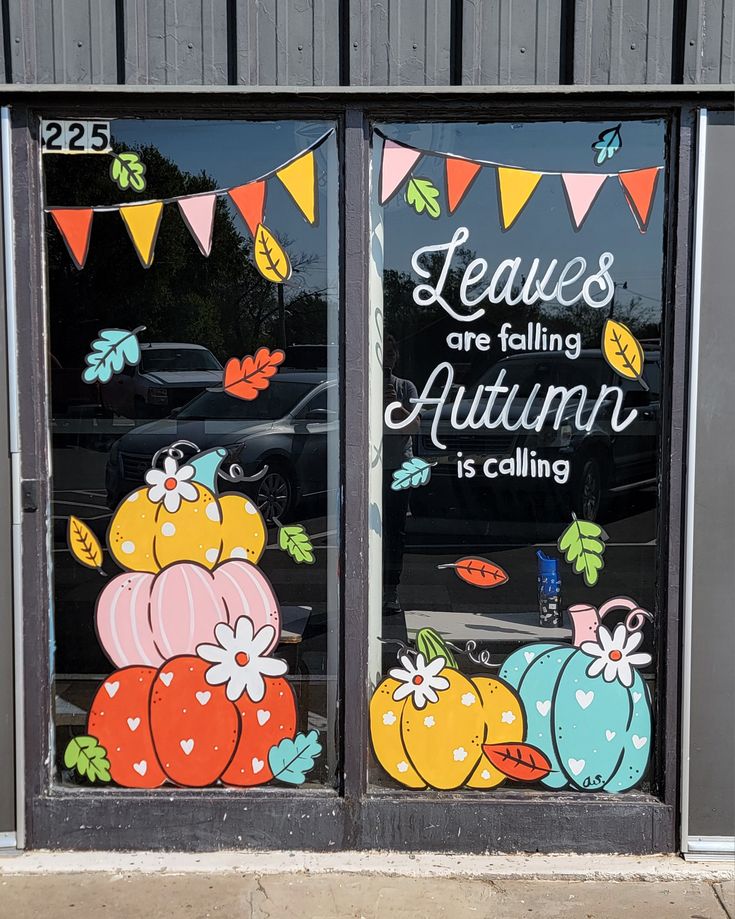 two windows decorated with fall decorations and saying leaves are falling autumn is calling