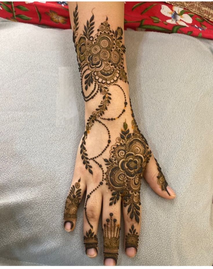 a woman's hand with henna tattoos on it