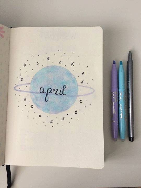 an open notebook with the word april written on it and two pens next to it