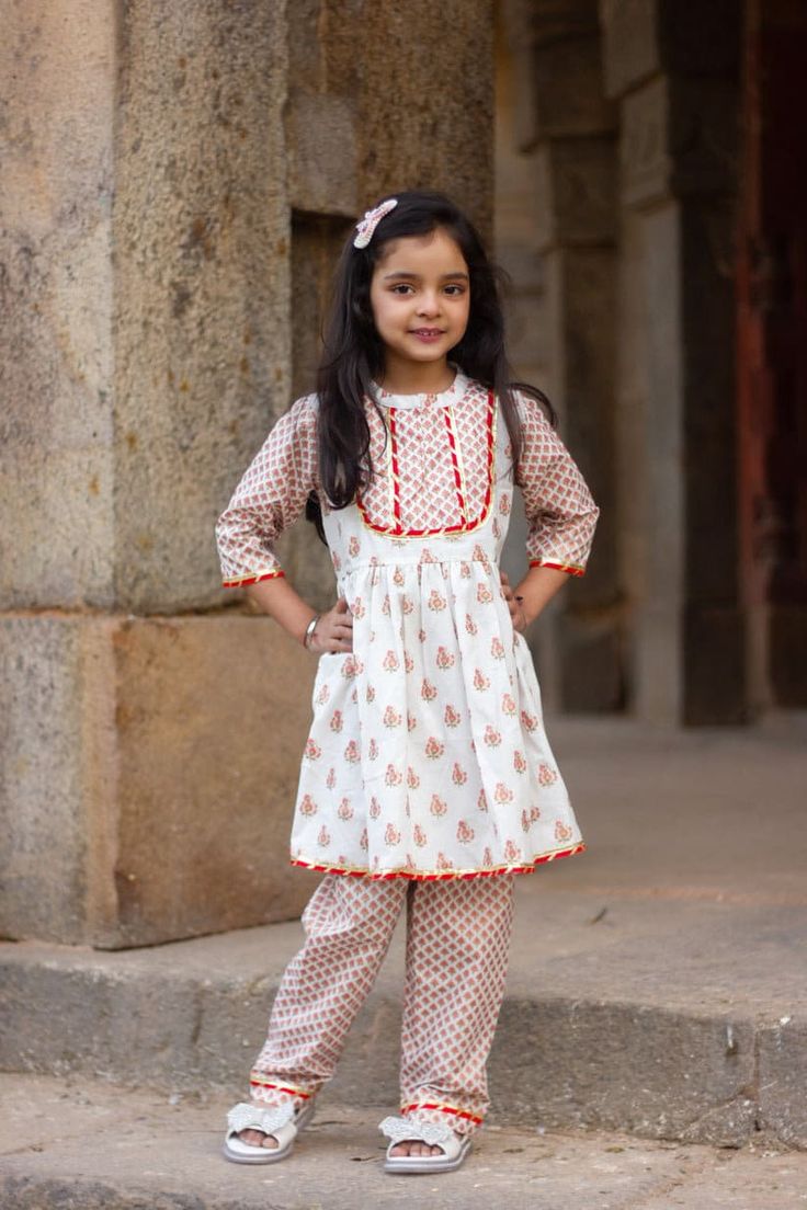 "Perfect for summer weddings and festivals this lehengha and top (set of 2) is an eye turner. Shouting with oodles of comfort during the festivities this cotton peplum suit is going to make your little one feel like herself while enjoying the festive season. Kurta - White base with pink floral print. Stand collar and embellished yoke. Payjama - Printed floral payjama makes it a comfy wear for your little ones as it comes with elasticated waist with drawstring for easy wear. Floral print  Fabric Festival Peplum Kurta, Anarkali Peplum Kurta For Festivals, Festive Navratri Kurta With Peplum Shape, Festive Navratri Peplum Kurta, Navratri Festive Peplum Kurta, Festive Peplum Kurta For Festivals, Traditional Navratri Peplum Dresses, Traditional Peplum Anarkali Set For Navratri, Summer Festive Lehenga With Printed Motifs