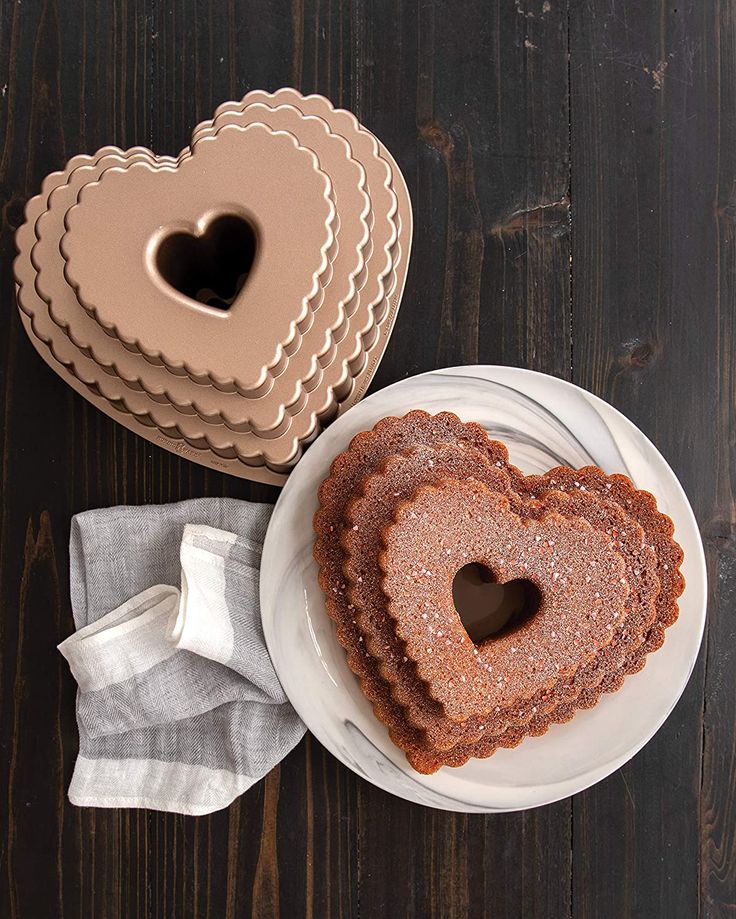 two heart shaped cakes sitting on top of a white plate next to a cake tin