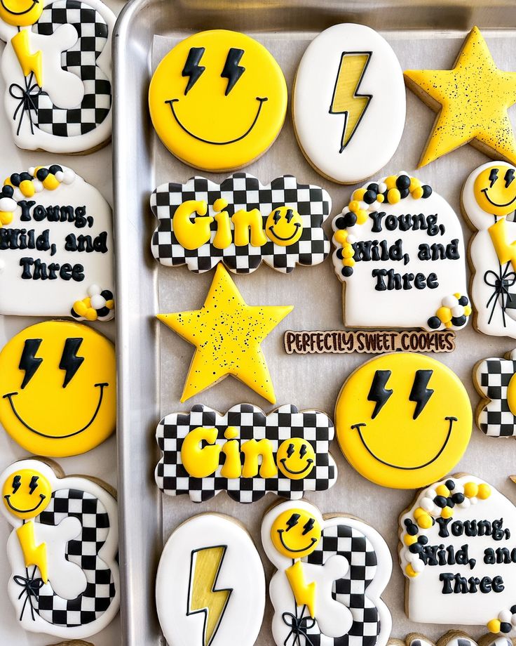 decorated cookies in the shape of smiley face and lightning bolt, with words on them