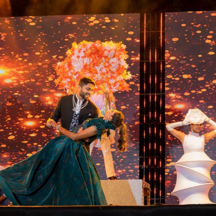 a man and woman dancing on stage at an event