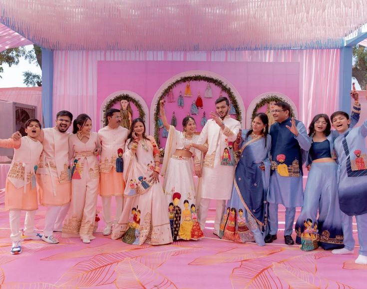 a group of people standing next to each other in front of a pink stage backdrop