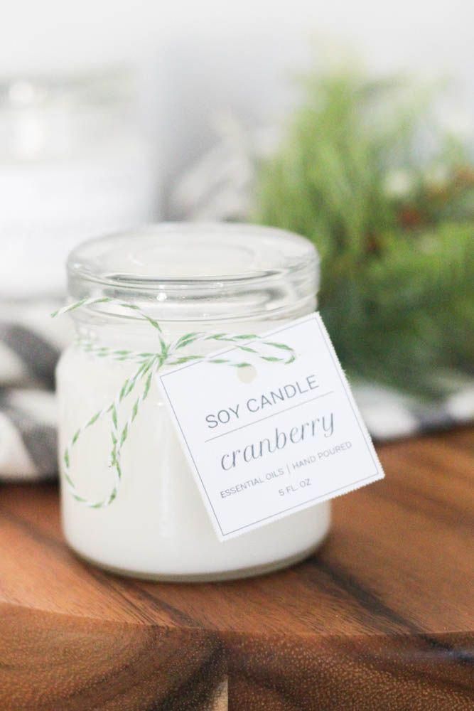 a candle sitting on top of a wooden table next to a jar with a label that says soy candle cranberry