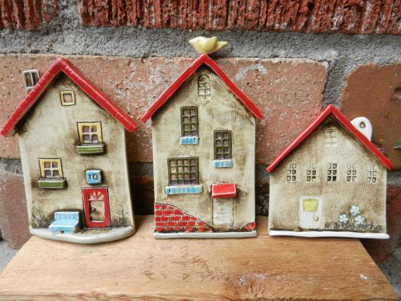 three ceramic houses sitting on top of a wooden table