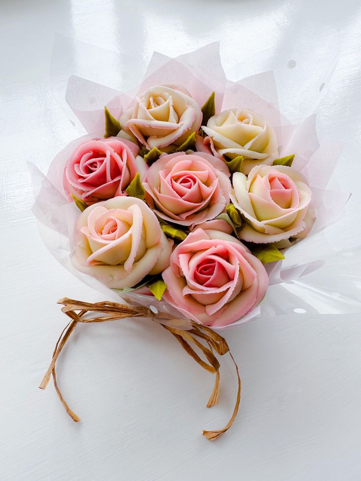 a bouquet of pink roses sitting on top of a white table