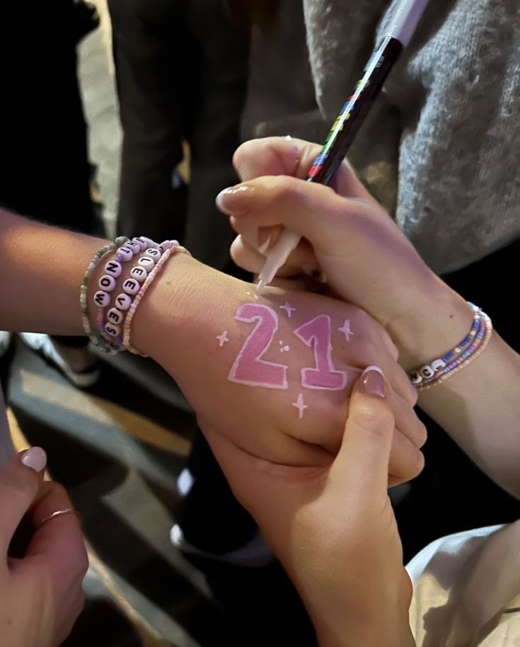 two people holding onto each other's hands with numbers painted on their arms and fingers