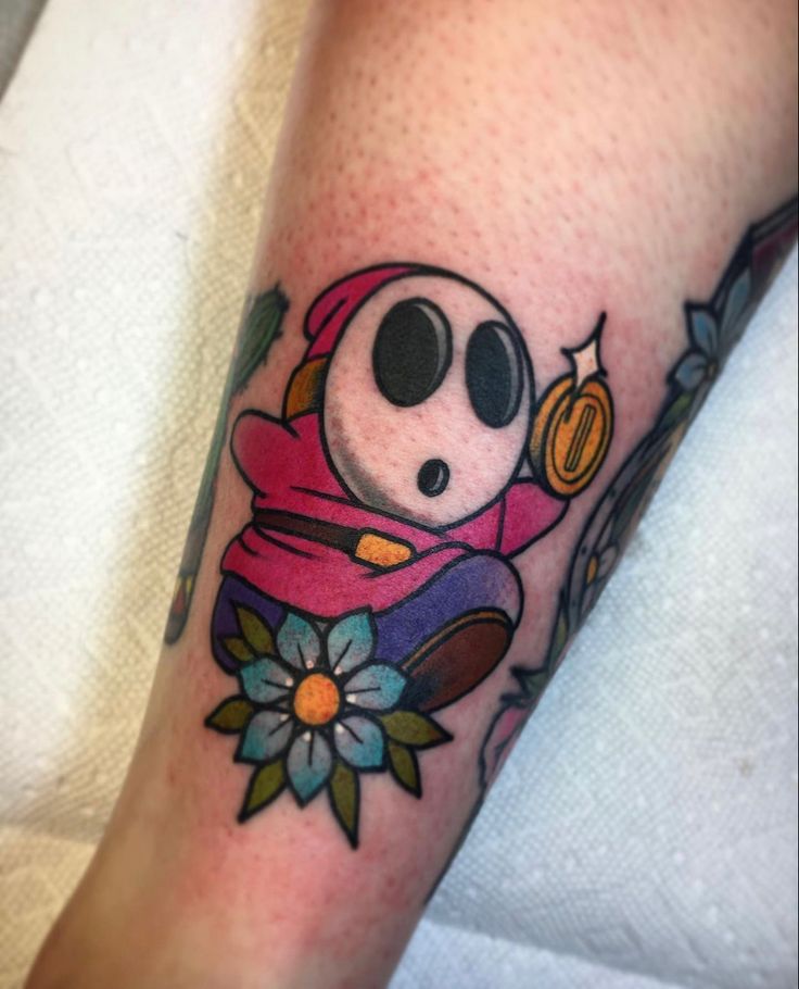 a person with a tattoo on their leg that has an image of a cartoon character