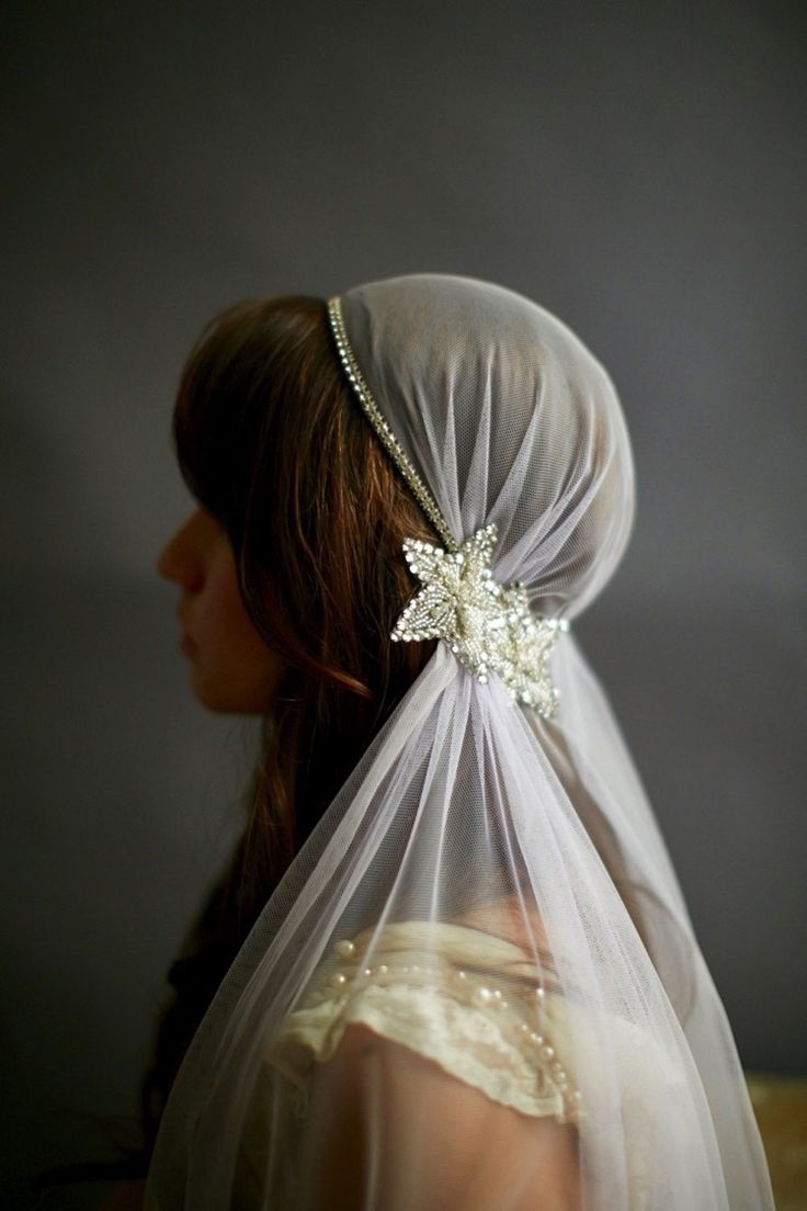 a woman wearing a veil with flowers on it