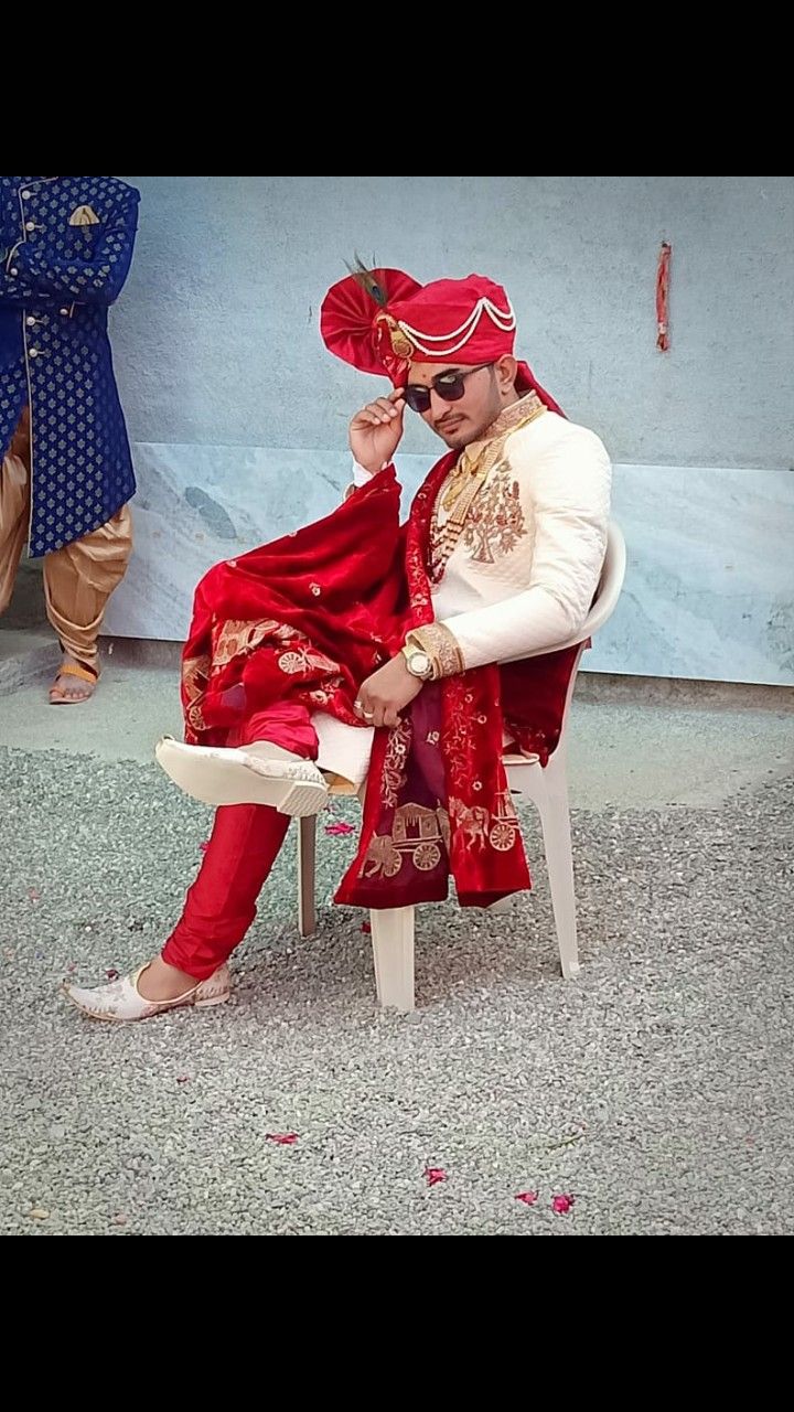 a man dressed in red sitting on a white chair