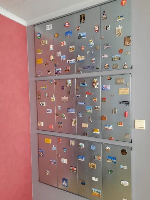 the wall is covered with magnets and stickers