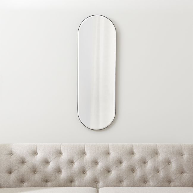 a couch with a mirror on the wall above it