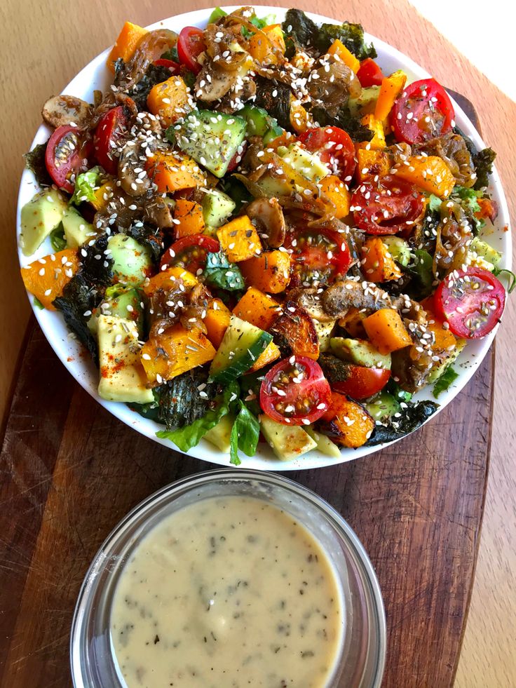 a salad with dressing in a bowl on a wooden table