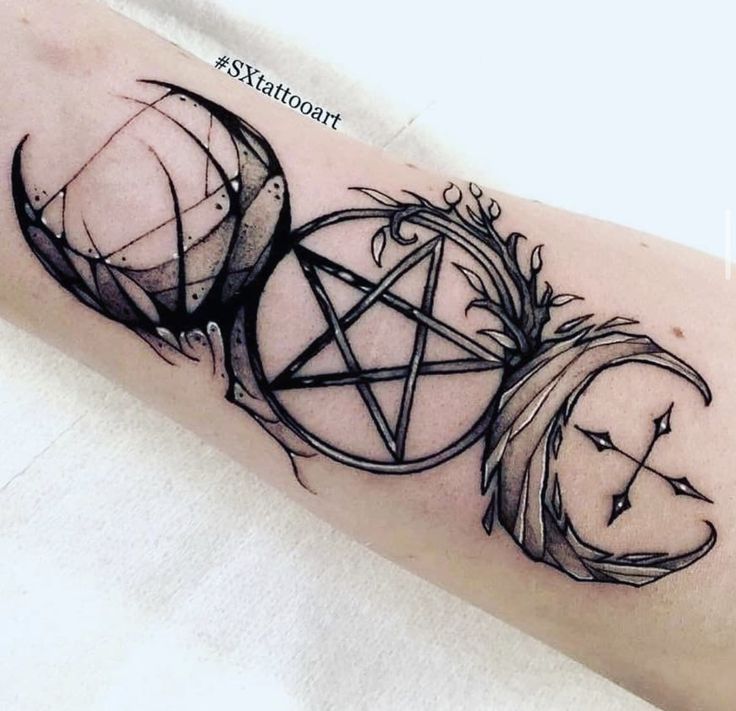 a black and white photo of a tattoo on the arm with an inverted pentagramil