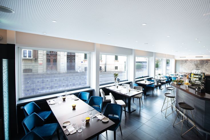 an empty restaurant with blue chairs and tables