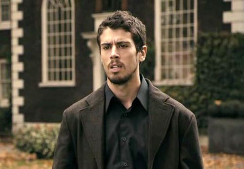 a man standing in front of a black building