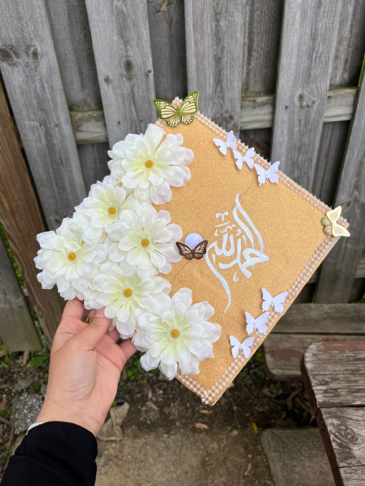 a person holding flowers in front of a wooden fence with the word,'i love you