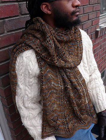 A cuddly wrap or scarf with columns of flying geese and cattail motifs, to keep even the coldest north wind away from neck and shoulders. Knit from hem to center back in two halves and grafted, the wrap is patterned for two lengths and the scarf for one. Shown here in Ball and Skein Artisan Merino & Silk, color End of WinterSuggested Yarns: Confection Sport, Shetlandia Sport, Targhee Tango Sport, Modern Deco Sport, Finn Dandy 3-ply Sport, Chebris Sport, or any light DK or sport-weight yarn. Subs Brown Knitted Shawl For Fall, Knit Shawl Scarves For Fall, Knitted Shawl Scarves For Fall, Knitted Shawl Pattern For Fall, Knitted Scarves For Fall, Winter Knitting Pattern For Scarf Shawl, Winter Knit Shawl Scarves, Hand Knitted Shawl Wrap For Fall, Hand Knitted Scarves For Fall