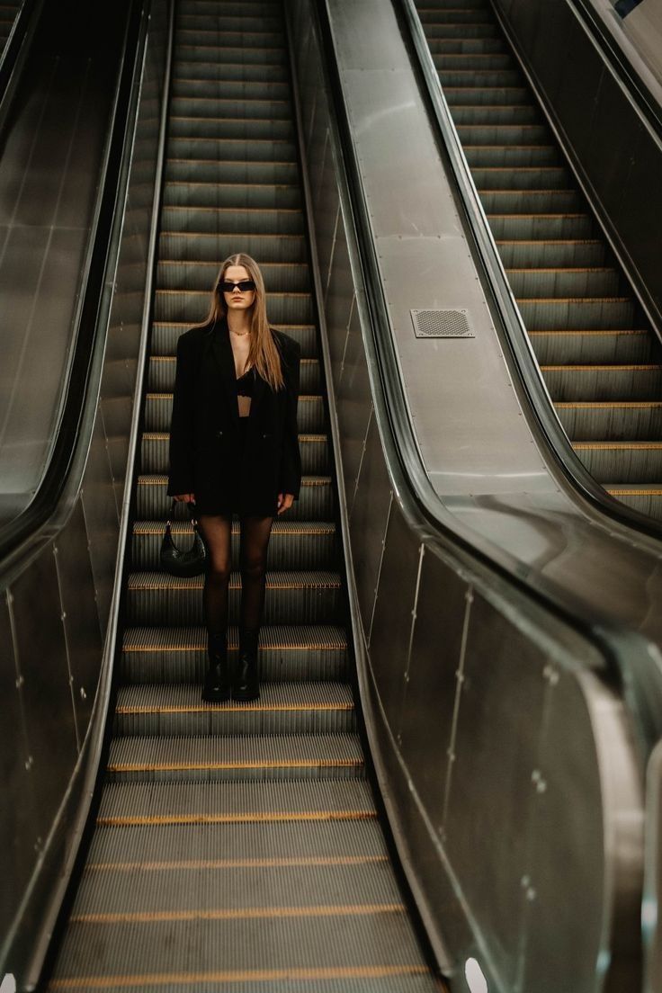 a woman standing on an escalator with her legs crossed