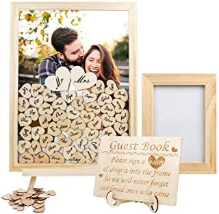 a wooden frame with two hearts on it next to a couple's wedding guest book