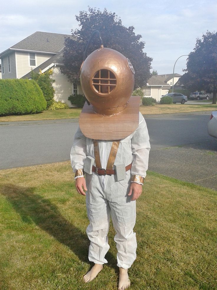 a man in a space suit is standing on the grass with his head tilted to the side