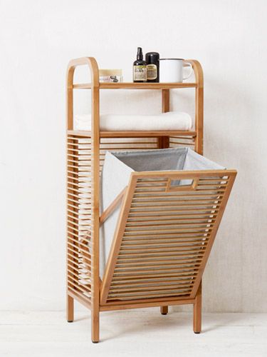 a wooden rack with two bins on it and a chair next to it in front of a white wall