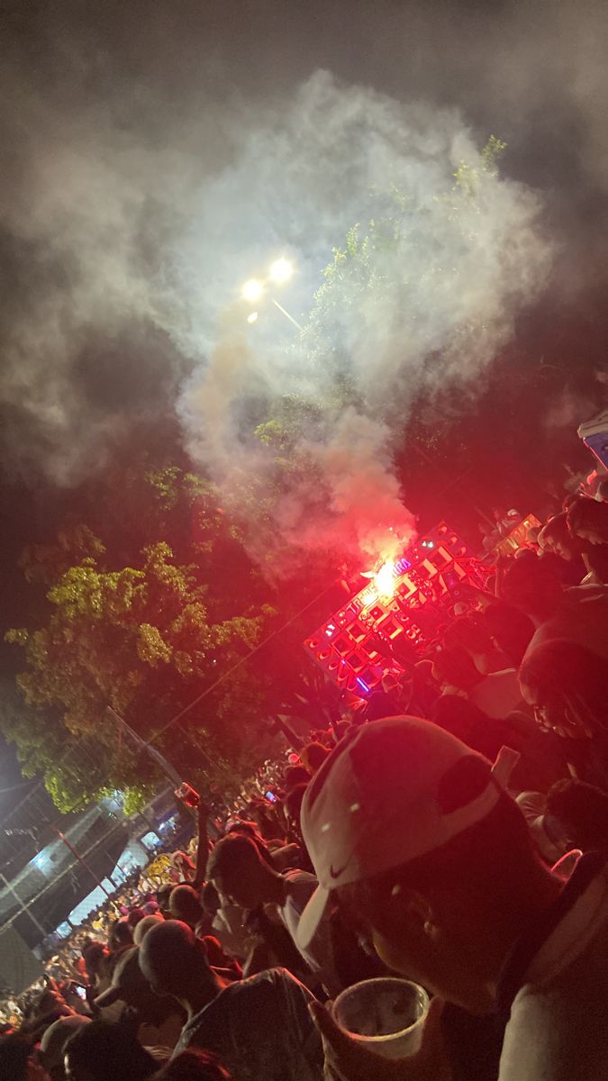 a large group of people watching fireworks in the night sky at a concert or festival