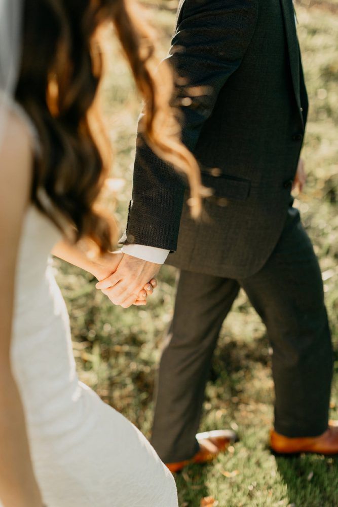 the bride and groom are holding hands