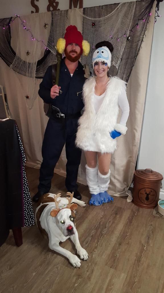 a man and woman dressed in costumes standing next to a dog on the wooden floor