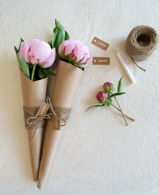 three flowers in vases tied with twine and some tape on the floor next to them