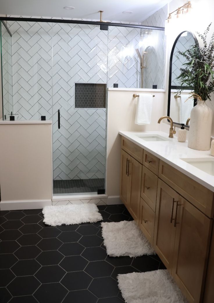 a bathroom with black and white tile flooring and wooden cabinetry, along with a walk in shower