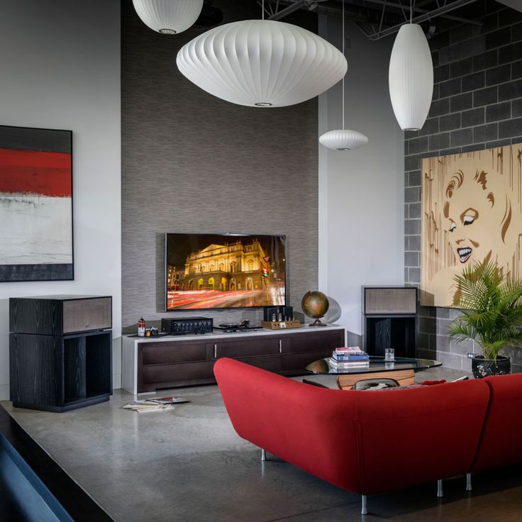 a living room filled with furniture and a flat screen tv on top of a wall