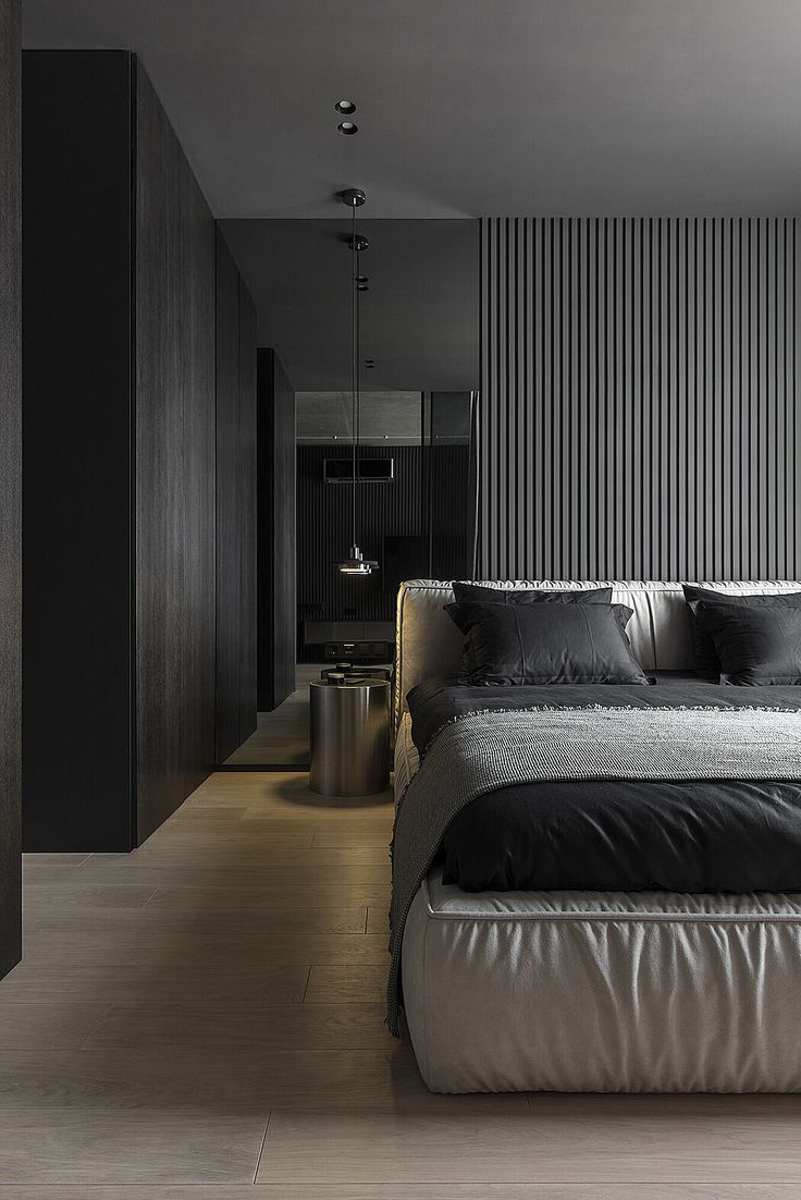 a large bed sitting in the middle of a bedroom next to a wall with vertical stripes on it