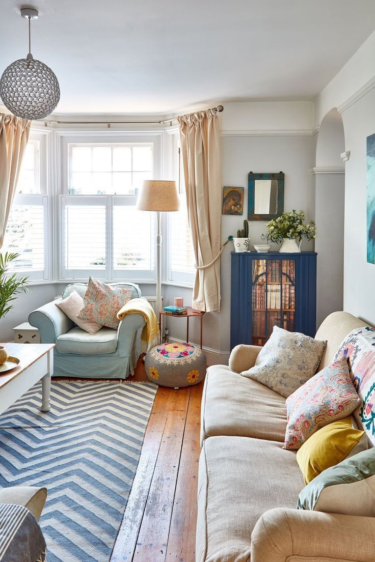 a living room filled with furniture and a fire place next to a window covered in curtains