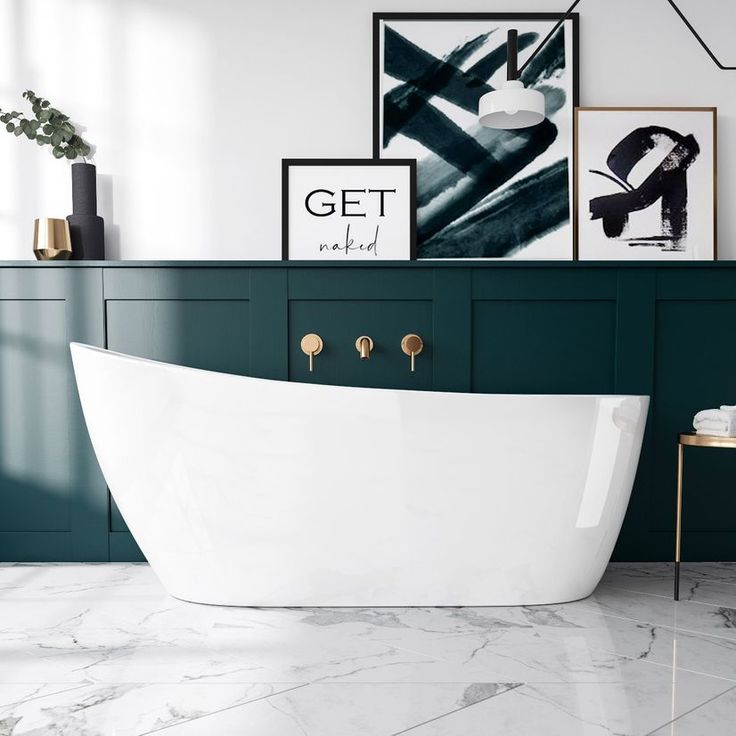 a white bath tub sitting in a bathroom next to a wall with pictures on it