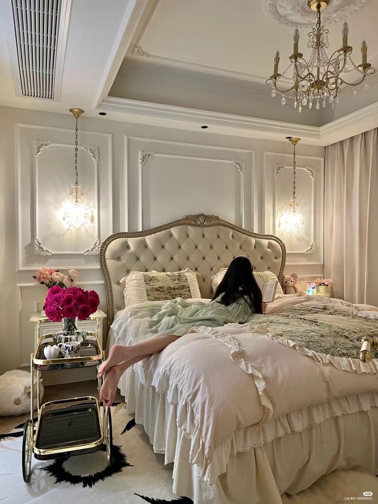 a woman laying on top of a bed in a bedroom