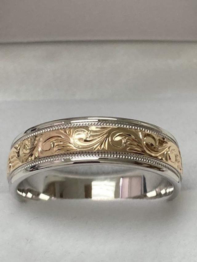 a wedding band with an intricate design on the inside and outside, in yellow gold or white gold