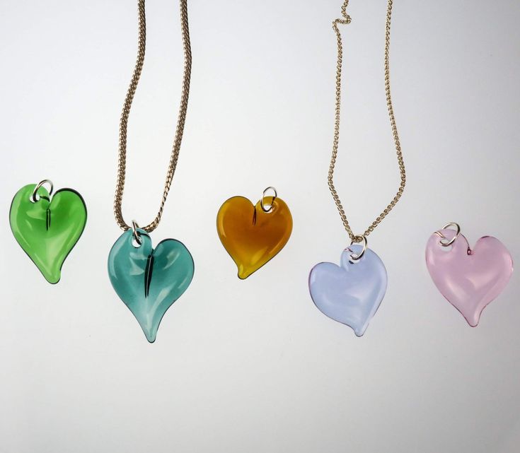 Handcrafted by Dan Neff, these heart pendants are the perfect way to show your love. They are available in amber, green, teal, purple, pink, and red. *Please note that while we do our best to create a cohesive series, not every piece will be identical as it is all handmade and subject to variations. Includes gift box and black satin cord that is adjustable from 14" to 26". Dimensions: 1.5" long x 1" wide Green Heart-shaped Jewelry Gift For Her, Teardrop Heart Charm Jewelry Gift, Elegant Heart-shaped Clear Necklace, Elegant Clear Heart-shaped Necklace, Elegant Clear Heart Shaped Necklace, Elegant Clear Necklaces For Valentine's Day, Elegant Clear Necklace For Valentine's Day, Valentine's Day Glass Necklaces Gift, Glass Heart Pendant Necklace For Gift